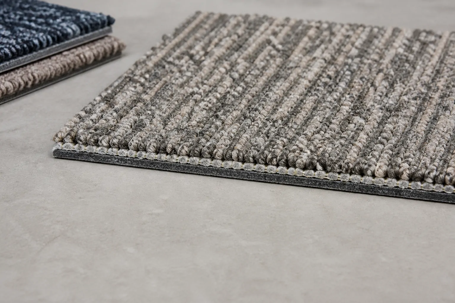 Commercial carpet tile construction showing pile and backing layers